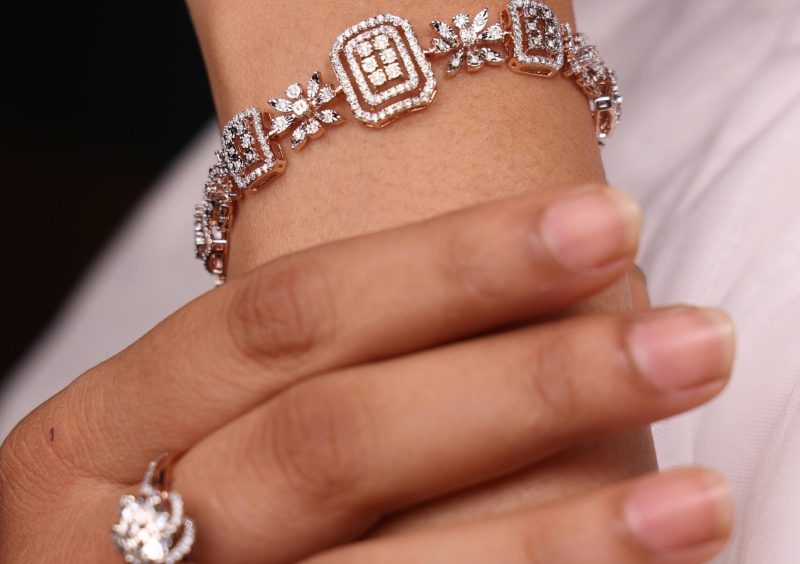 Close-up of a woman's hand showcasing a diamond bracelet and ring, highlighting their intricate design.